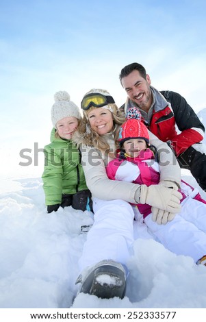 Cheerful family sitting in snow