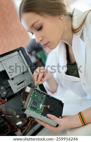Student girl in technology fixing computer hard drive