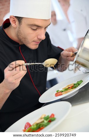 Chef in restaurant kitchen preparing dish