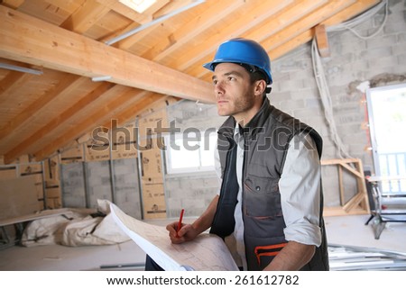 Construction manager on site reading blueprint
