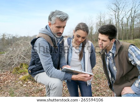 Teacher with students in cut forest