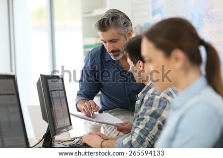 Teacher with young people in computing class