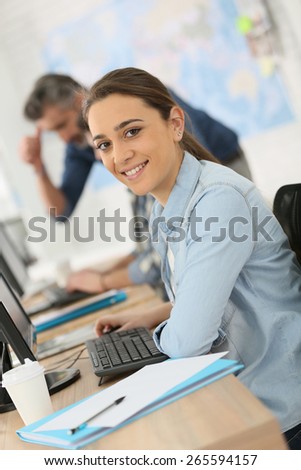 Portrait of smiling college girl working on desktop