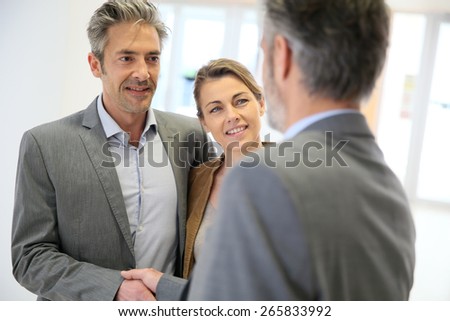 Adviser giving handshake to clients