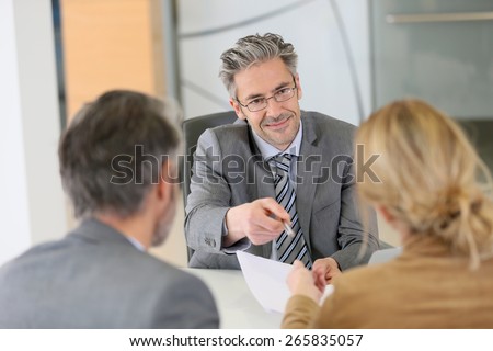 Mature couple signing contract in lawyer\'s office