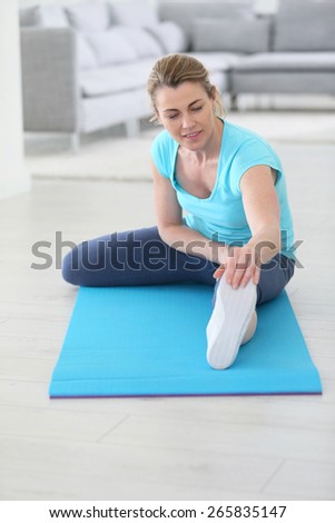 Middle-aged woman doing stretching exercises at home