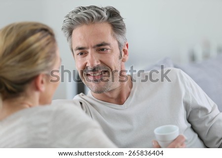 Mature couple talking together in sofa