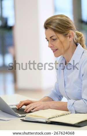 Businesswoman working in office on laptop