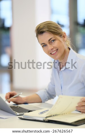 Businesswoman working in office on laptop