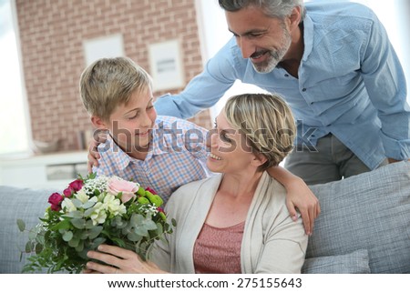 Young boy giving flowers to mommy for mother\'s day
