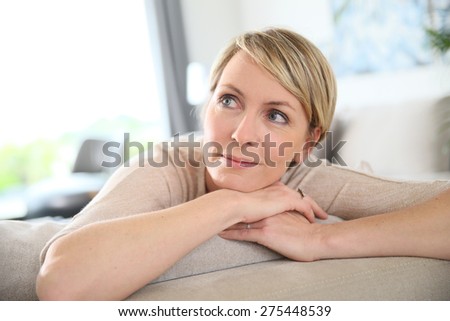 Middle-aged woman relaxing in sofa at home