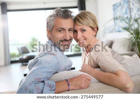 Middle-aged couple relaxing in sofa at home