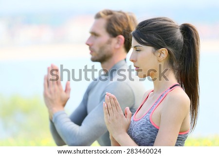 Couple doing meditation and yoga exercises in outdoor park