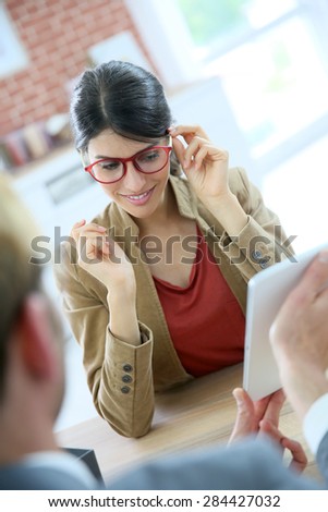 Woman in optical store choosing eyeglasses