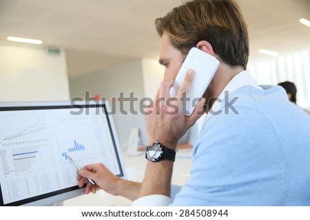 Bank trader negotiating on the phone from office