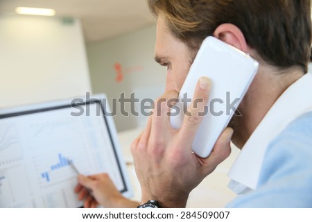 Bank trader negotiating on the phone from office