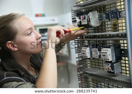 Young woman in professional training setting up electrical circuit