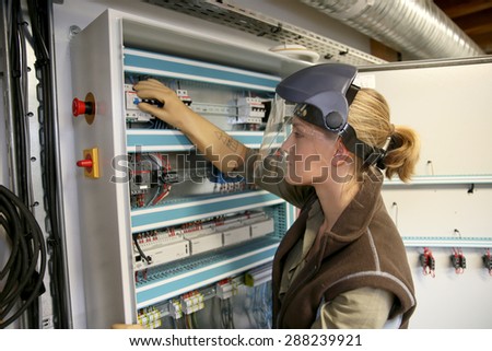 Young woman checking electrical system of heating room