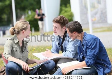 Young people sitting in park to study