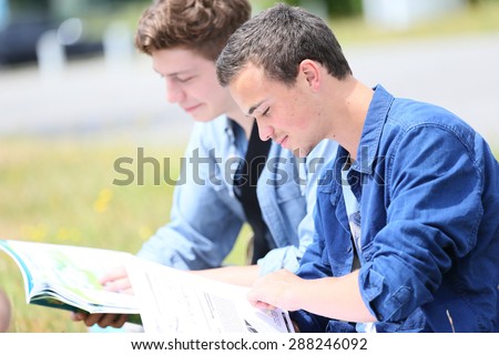 Young people sitting in park to study