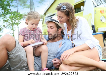 Family playing with video game on campground