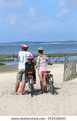 Family on a biking journey making a stop on the beach