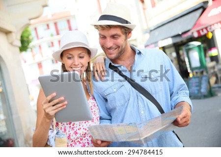 Couple in vacation looking at tourist guide on internet