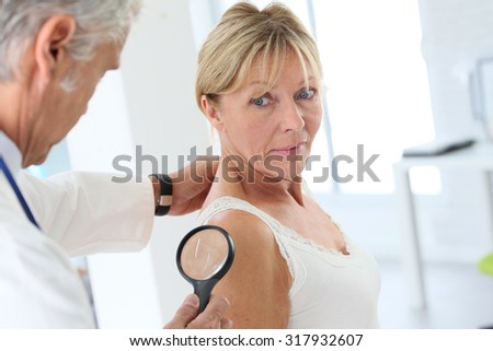 Elderly woman consulting doctor for skin control
