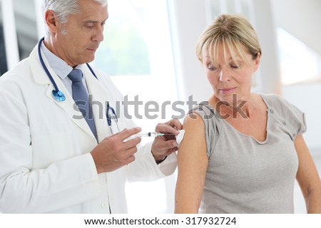 Doctor injecting flu vaccine to patient\'s arm
