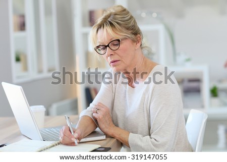 Portrait of senior woman working on laptop computer