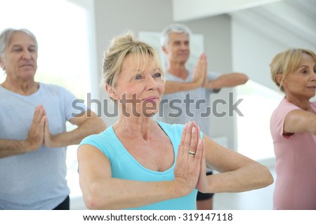 Group of senior people doing fitness exercises in gym