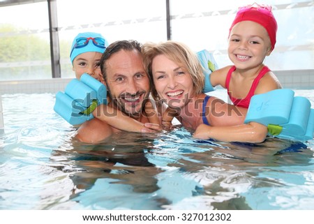 Portrait of family having fun in public indoor swimming-pool