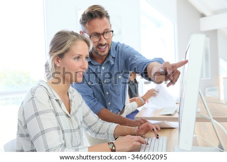 Student girl with teacher working on desktop computer