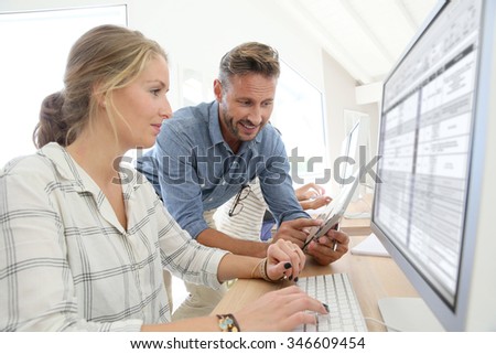 Student girl with teacher working on desktop computer