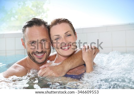 Couple enjoying hot tub bath in spa center