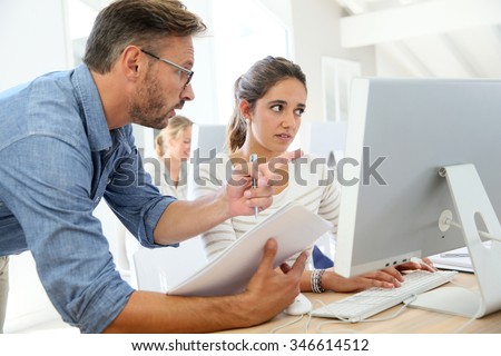 Teacher with student working on computer