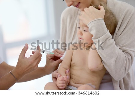 Baby girl at doctor\'s office receiving vaccine injection