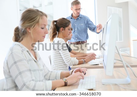 Student girl in class sitting in front of desktop computer