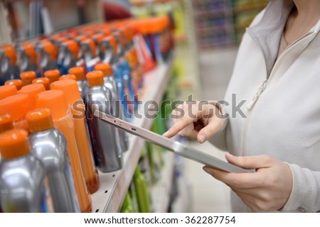 Woman merchandiser checking products available with digital tablet