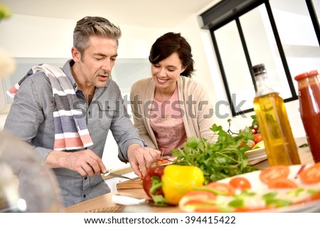 Middle-aged couple having fun cooking together