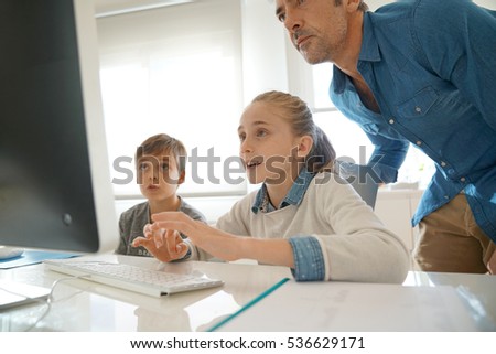 Teacher with school kids in computer laboratory