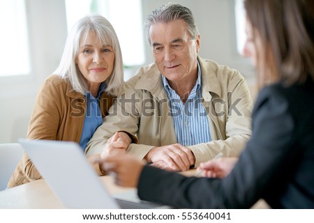 Senior couple meeting financial adviser for investment