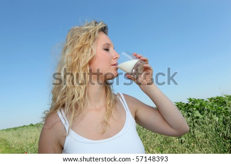 Closeup of young woman drinking milk