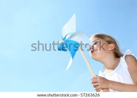 Closeup of little girl blowing blue wind wheel