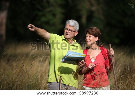 Senior couple rambling in countryside with map