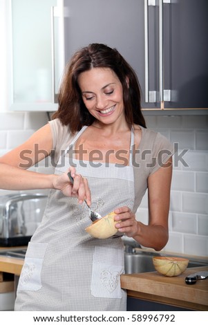 Woman in kitchen fixing dinner