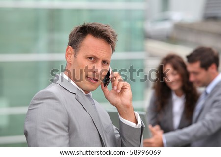 Businessman standing in front of offices outside
