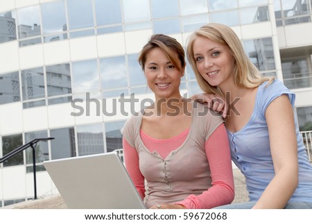 Girl friends in college campus with laptop computer