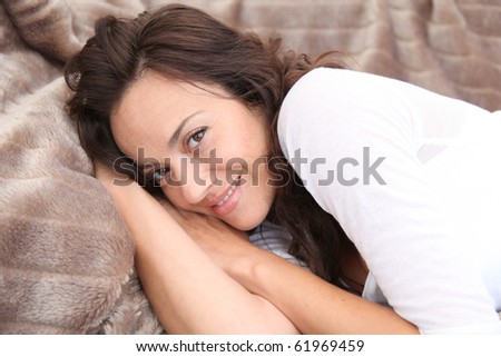 Closeup of beautiful woman laying in soft blanket
