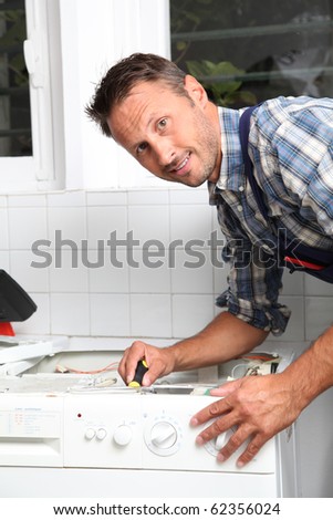 Plumber fixing broken washing machine